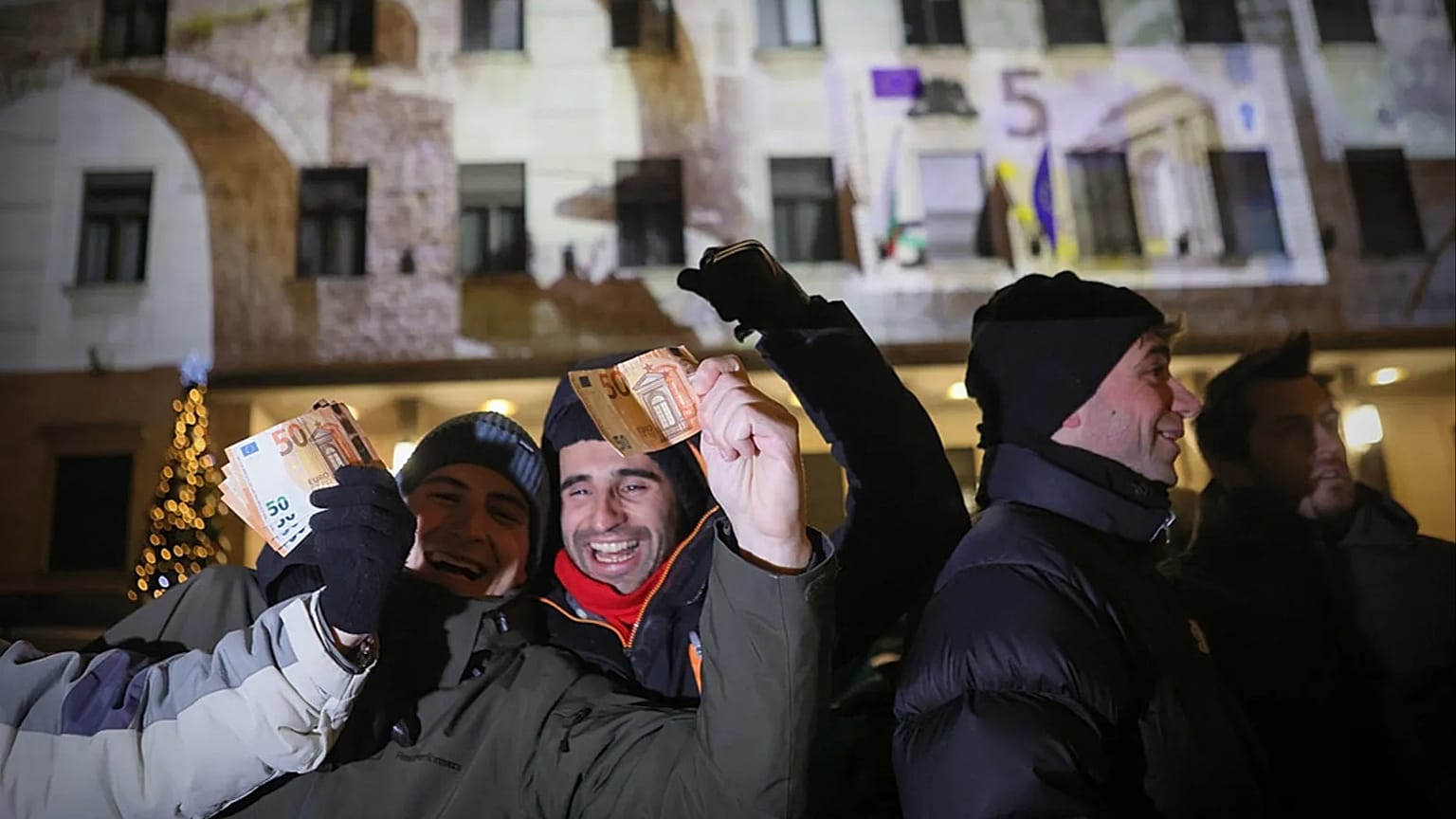 People pose holding euro banknotes as they celebrate the New Year and Bulgaria's adoption of euro in front of Bulgarian National Bank in Sofia, 1 January 2026