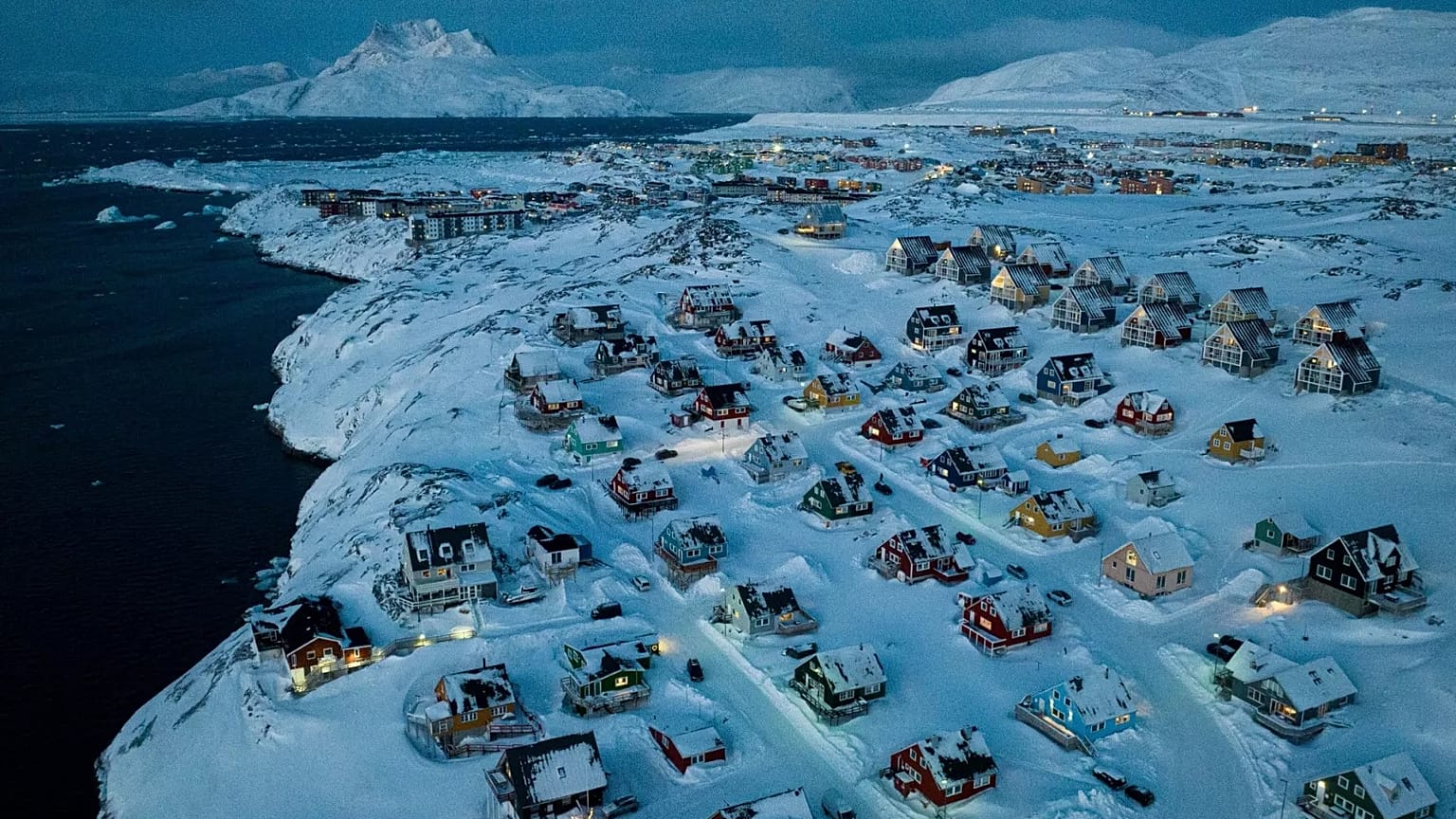 Houses covered by snow are seen on the coast of a sea inlet at Nuuk, 7 March, 2025