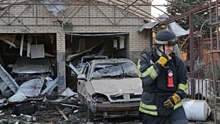 FILE: A rescue worker walks in front of a residential house damaged after a Russian attack on Zaporizhzhia, 19 December 2025