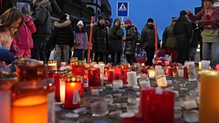 People light candles near the sealed off Le Constellation bar in Crans-Montana, Swiss Alps, Switzerland, Friday, Jan. 2, 2026.