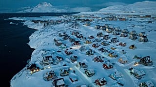 Houses covered by snow are seen on the coast of a sea inlet at Nuuk, 7 March, 2025