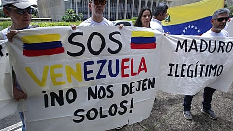 480x270_cmsv2_14a34d29-f73a-56ab-9633-10885baef676-9599718 FILE - On 10 January 2019, Venezuelan citizens living in Brazil hold signs that read in Spanish "S.O.S. Venezuela. Don't leave us alone," left, and "Maduro. Illegitimate."