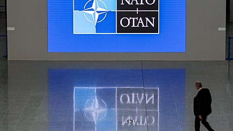 A man walks in the lobby of the NATO headquarters, Wednesday, Nov. 16, 2022 in Brussels.