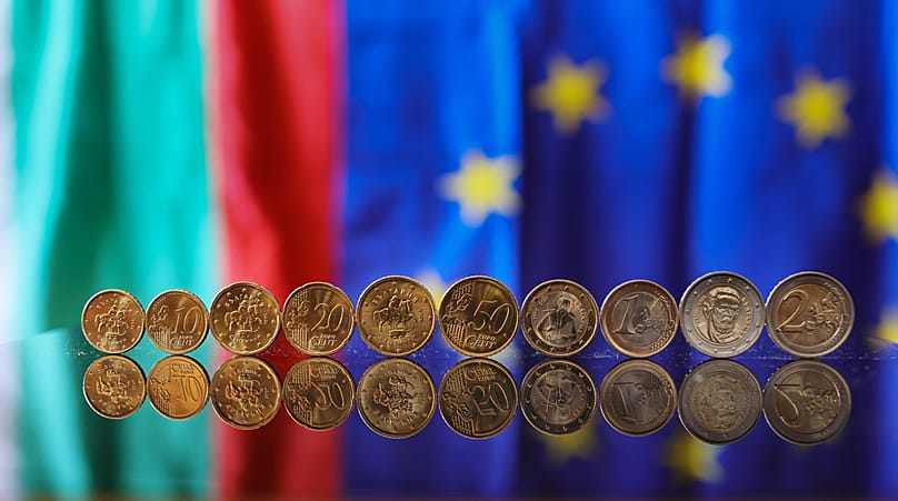 New euro coins with Bulgarian symbols reflected in a table seen backdropped by Bulgarian and EU flag, in Sofia, 30 December 2025