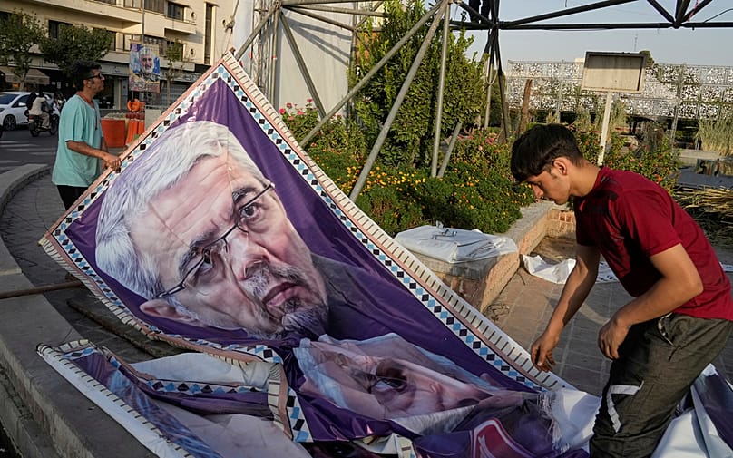 Workers prepare a portrait of late chief of the general staff of Iran's army, Gen Mohammad Hossein Bagheri,killed in Israeli strike in June, in Tehran, 22 September 2025