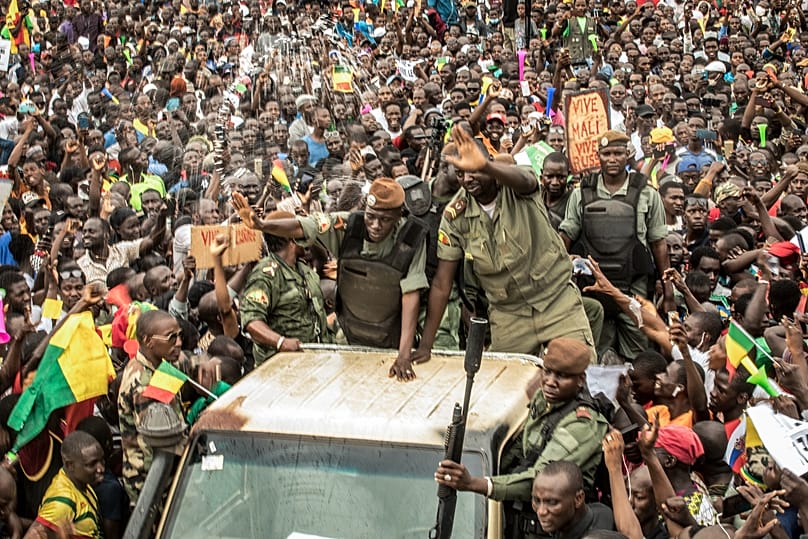 An unidentified junta representative waves as Malians supporting the recent overthrow of President Ibrahim Boubacar Keita celebrate in Bamako, 21 August, 2020