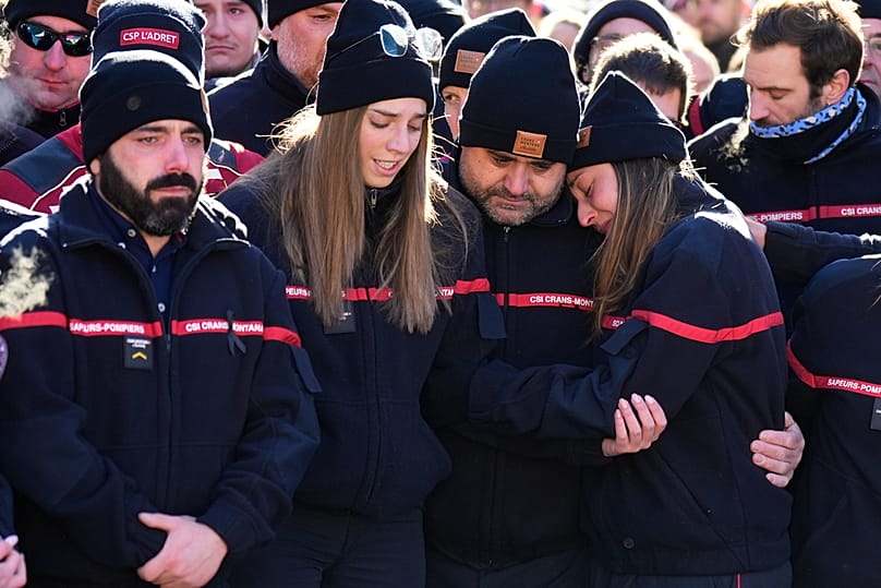 Firefighters cry as they attend a memorial march in Crans-Montana, Swiss Alps, Switzerland, Sunday, Jan. 4, 2026, after a devastating fire in Le Constellation bar left dead an