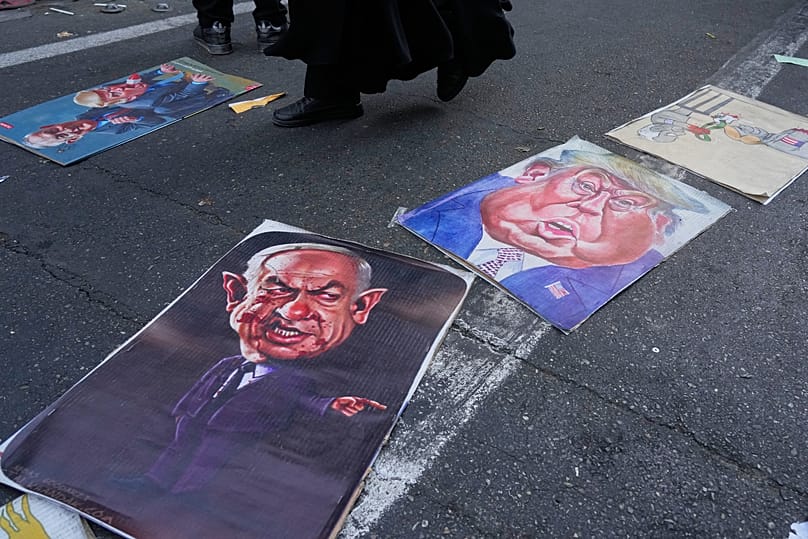 Satirised portraits of the Israeli Prime Minister Benjamin Netanyahu and US President Donald Trump are placed on the ground in Tehran, 4 November, 2025