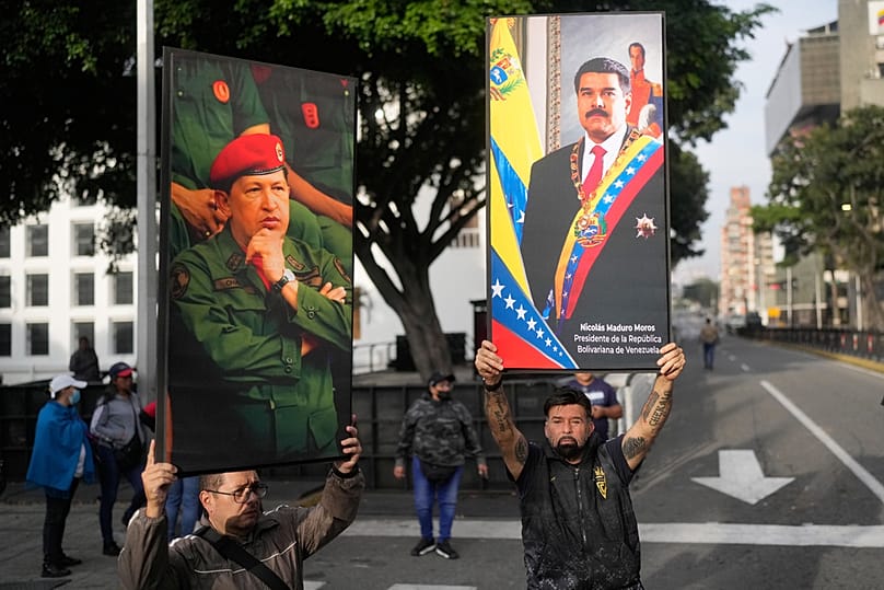 Government supporters display posters of Venezuelan President Nicolás Maduro, right, and former President Hugo Chávez in downtown Caracas, Venezuela, Saturday, 3 Jan, 2026.