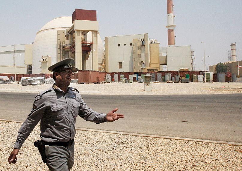 An Iranian security officer directs media at the Bushehr nuclear power plant, 21 August, 2010