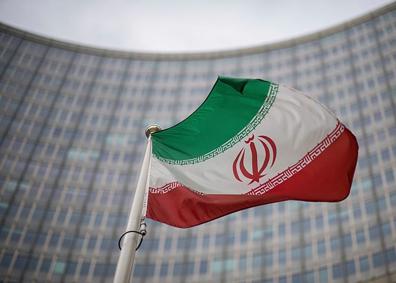 A national flag of Iran waves in front of the building of the International Atomic Energy Agency in Vienna, 17 December, 2021