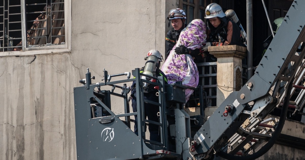 Đưa 2 nạn nhân xấu số ra khỏi hiện trường đám cháy nhà 7 tầng ở Hà Đông